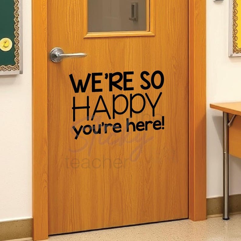 We're So Happy You're Here classroom door vinyl decal on wooden door with small window