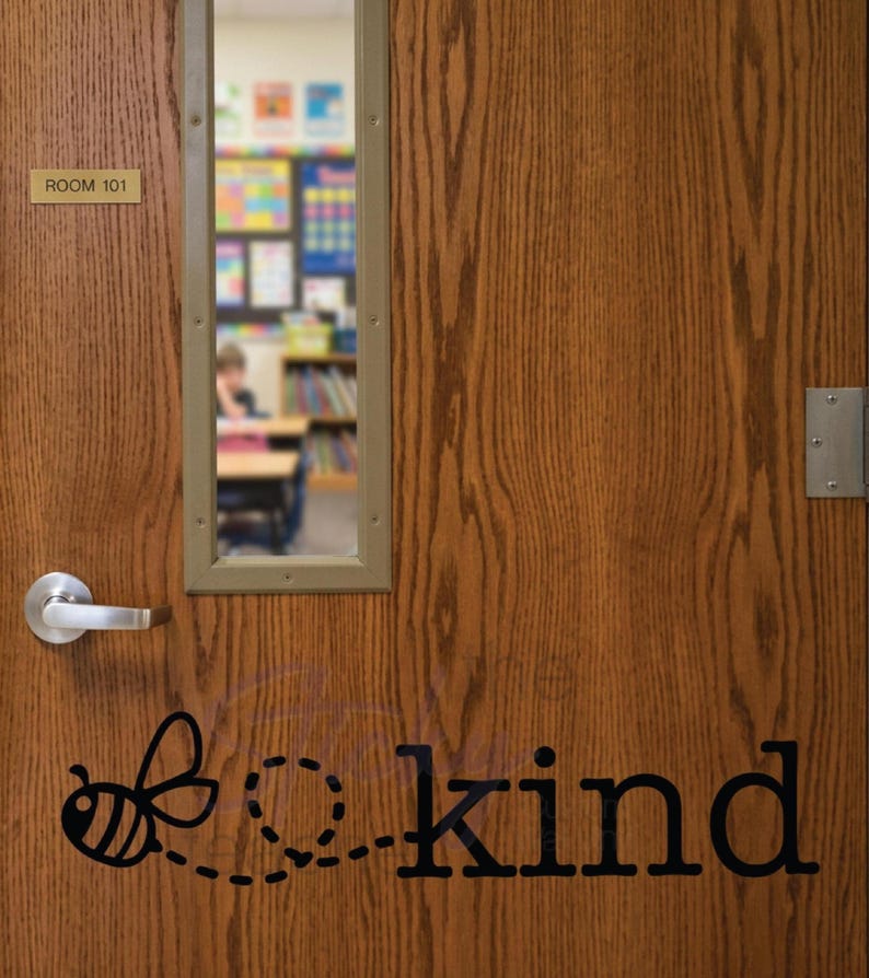 Bee Kind decal on wooden classroom door with Room 101 sign