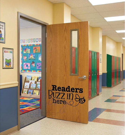 Readers Buzz in Here classroom door vinyl decal on wooden door with colorful lockers and reading corner visible