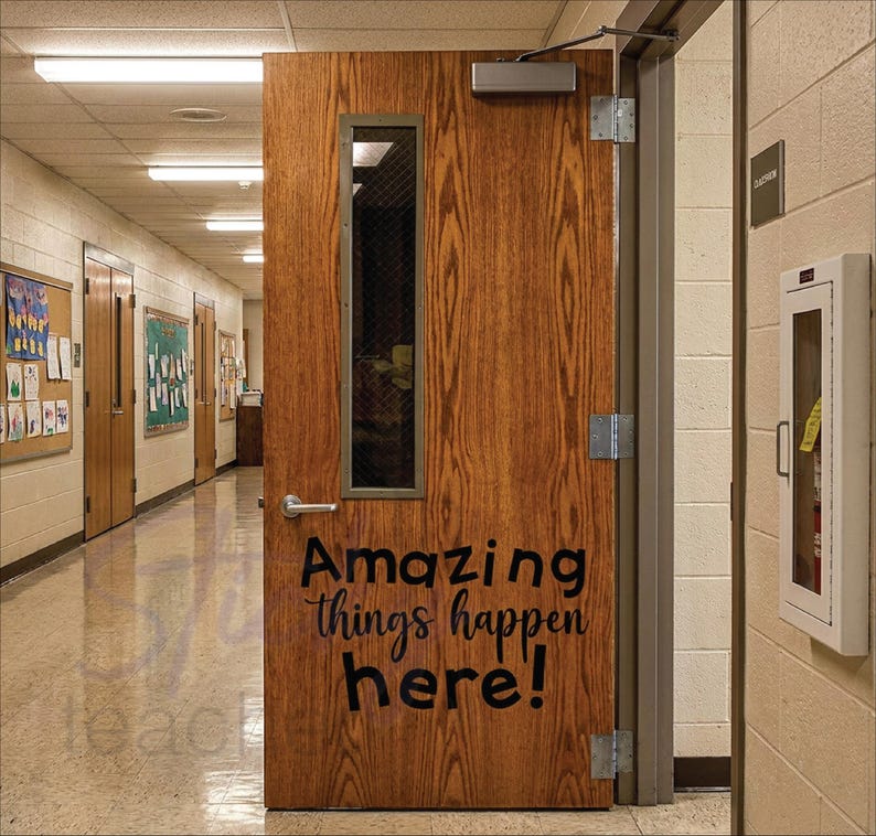 Amazing Things Happen Here decal in black script in school hallway