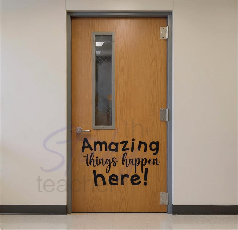 Amazing Things Happen Here decal in black on wooden classroom door